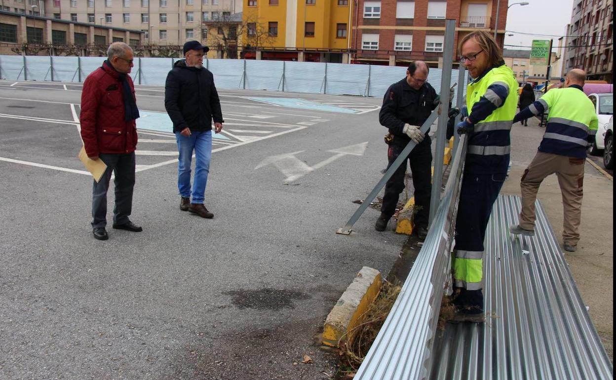 Operarios municipales retiran las vallas para reabrir el aparcamiento de la calle Obispo Osmundo en presencia de los concejales de Urbanismo y Mantenimiento.