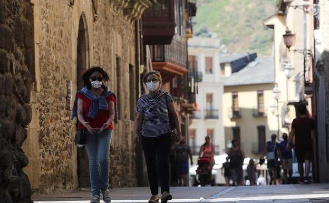 Dos mujeres caminan por la calle del Reloj de Ponferrada con sus respectivas mascarillas.