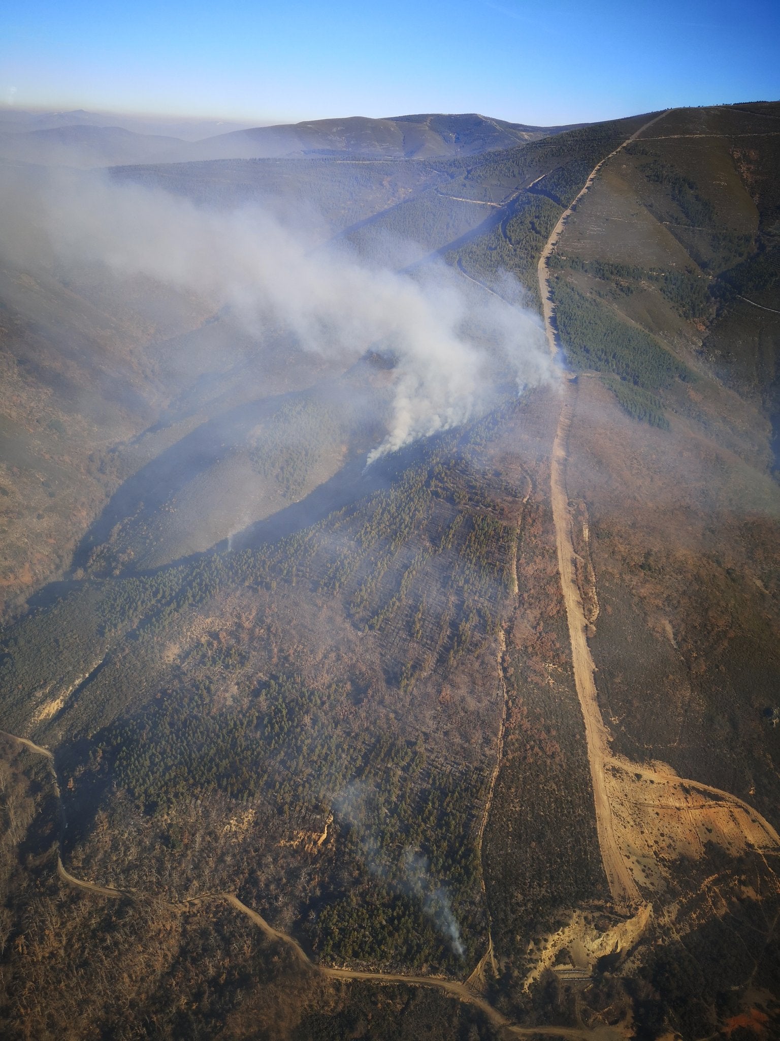 Varios brigadistas y helicópteros trabajan en la extinción de un incendio decretado este martes.