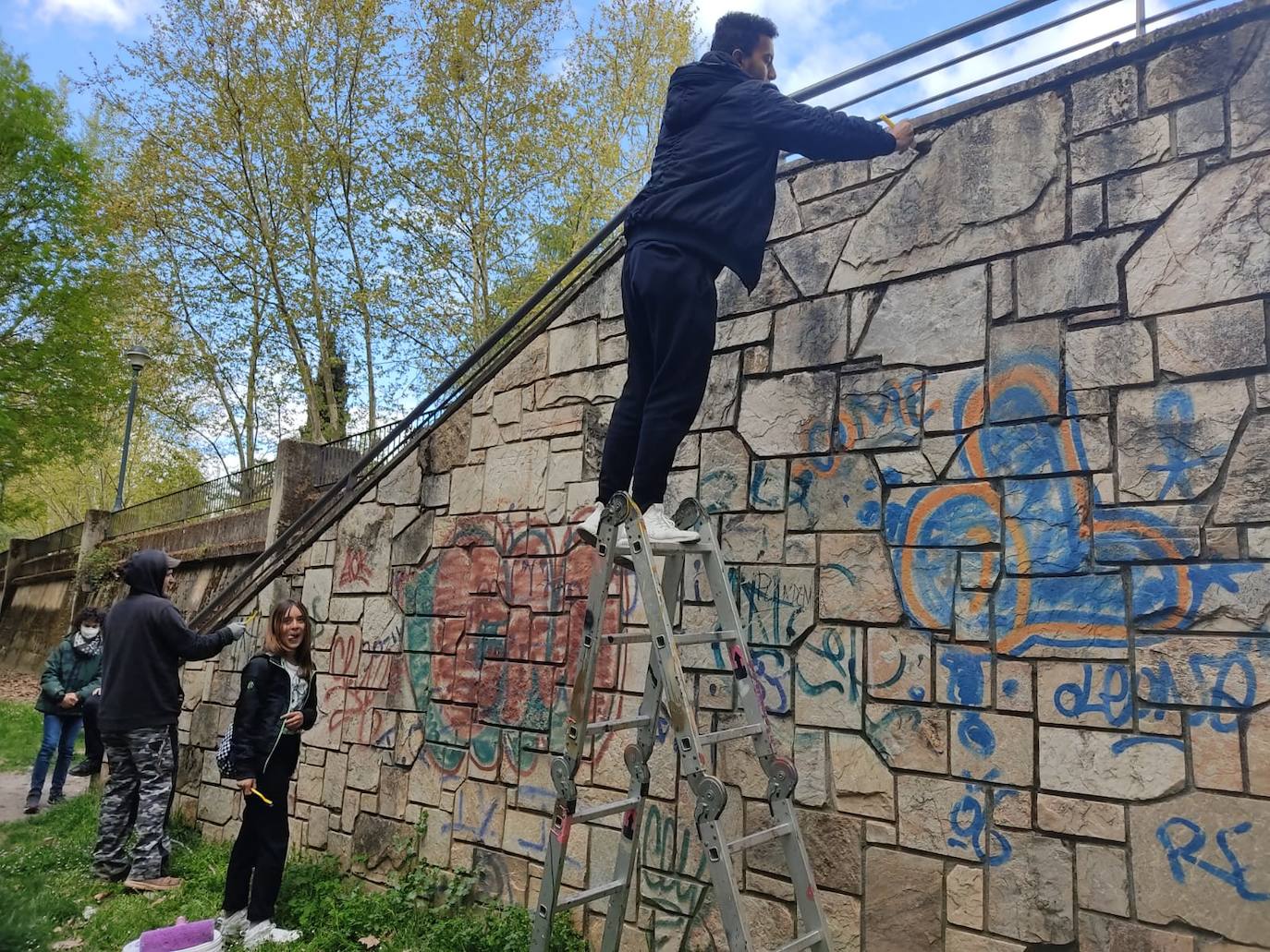 Los alumnos del colegio Jesús Maestro elaboran un mural en el Paseo del Río de Ponferrada.