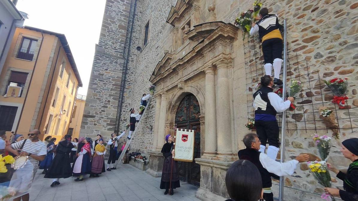 Grupos folklóricos llenan de flores la entrada a la basílica de la Encina.