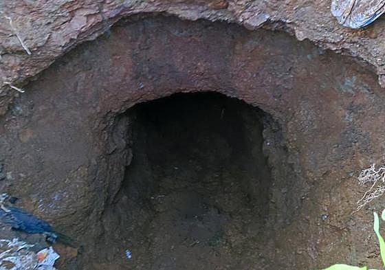 Imagen del socavón que hay en el suelo, al lado de las casas.