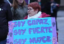 Imagen de una mujer con un cartel durante un acto del 8M.