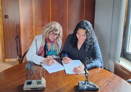 La alcaldesa de Fabero, Mari Paz Martínez, y la concejal de IU, Sasquia Julio, en la firma del pacto de gobierno.
