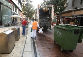 Operarios de FCC realizan labores de recogida de basuras en calles del centro de Ponferrada.