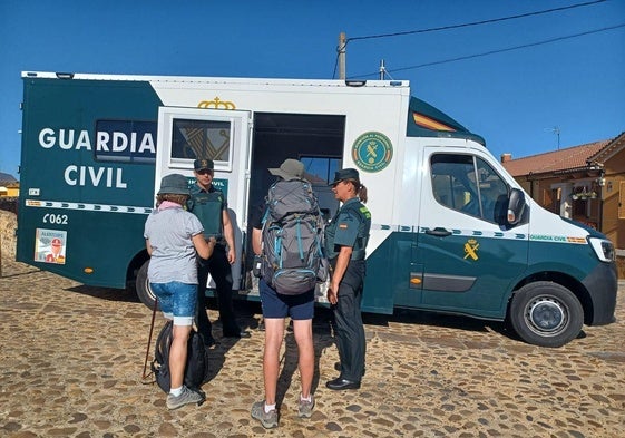 Miembros de la Guardia Civil atendiendo a dos peregrinas.