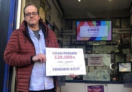 José Luis Salas muestra el cartel con el premio de 120.000 euros del sorteo de Eurodreams que ha repartido.