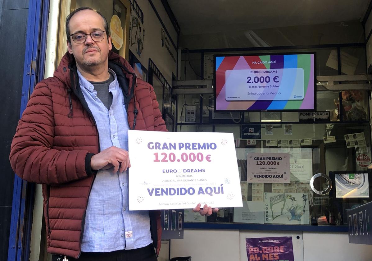 José Luis Salas muestra el cartel con el premio de 120.000 euros del sorteo de Eurodreams que ha repartido.