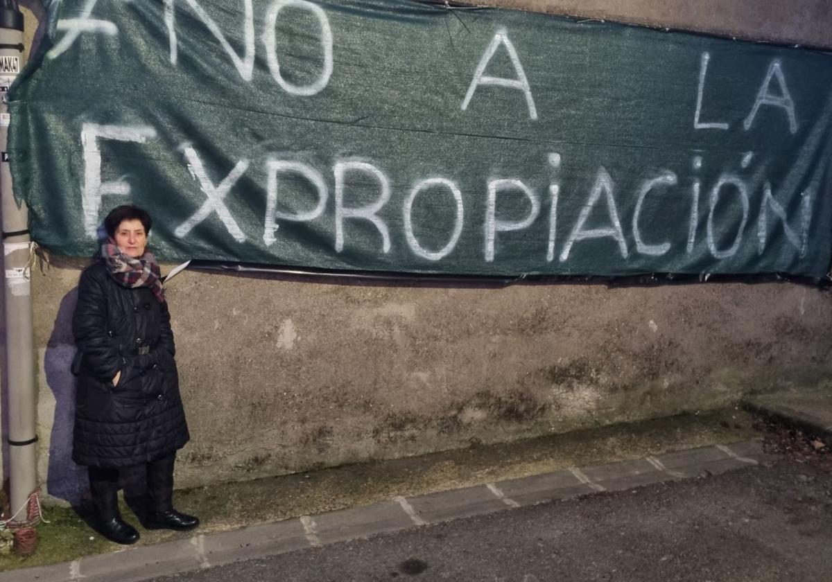 Encarna junto a la pancarta contra la expropiación que ha presidido en los últimos meses la fachada lateral de su vivienda en el barrio de San Andrés.