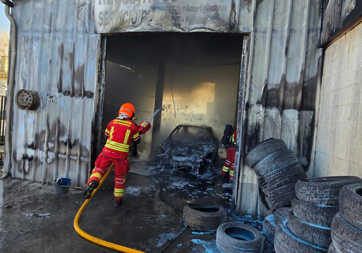 Imagen principal - Los bomberos de Ponferrada sofocaron las llamas del fuego que calcinó la nave anexa al taller.