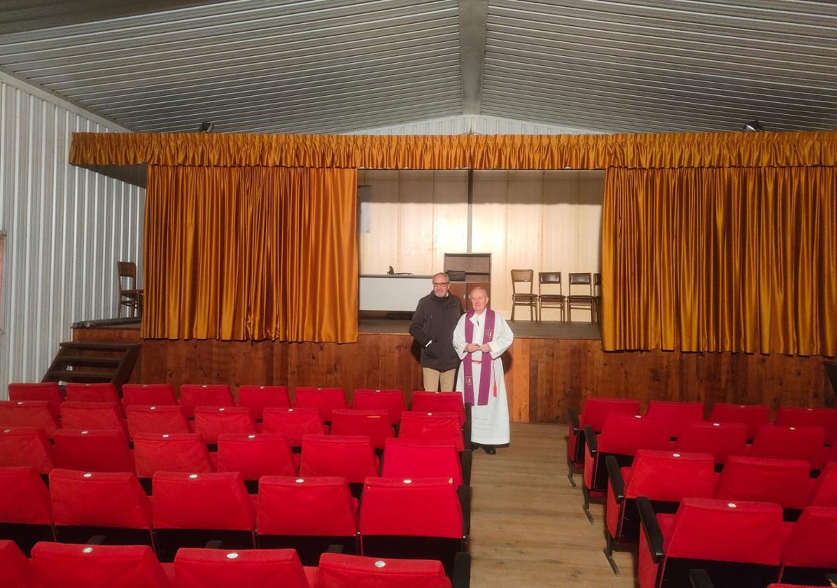 Imagen principal - El cura párroco de Villaverde de la Abadía y el presidente del Consejo Comarcal del Bierzo en el salón de actos que atesora las butacas del cine Morán.