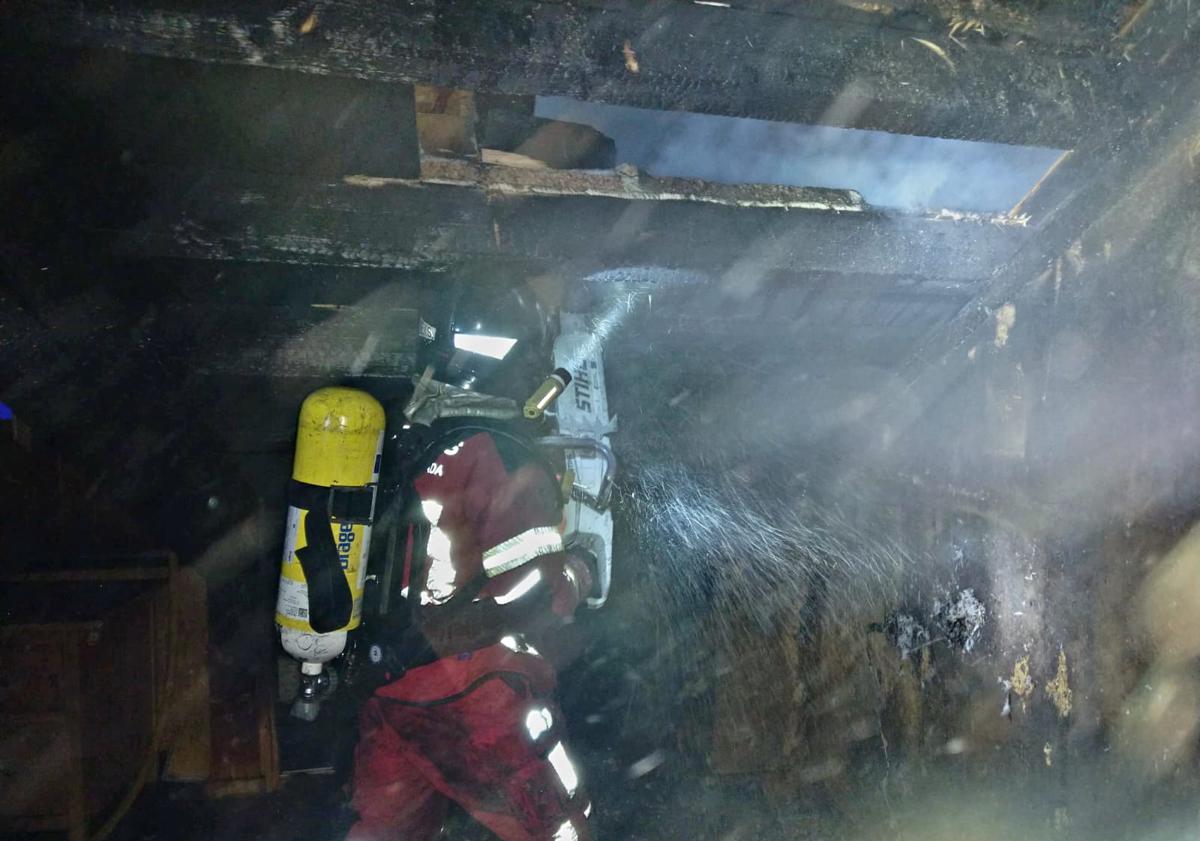 Imagen principal - Un incendio destroza la cubierta de una vivienda de madera y pizarra en Valtuille