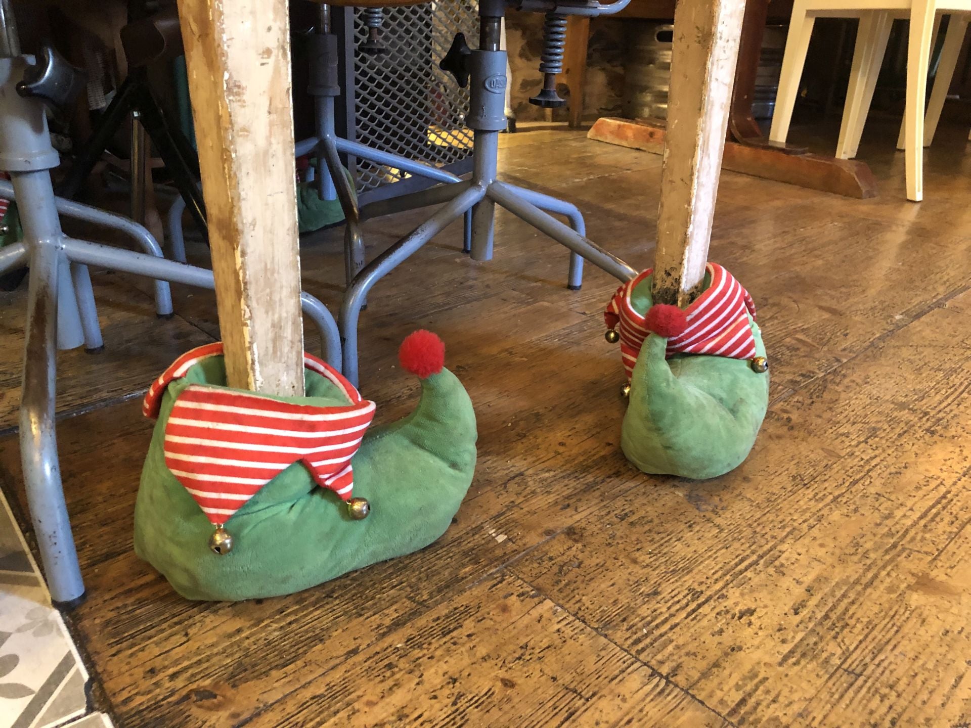 Unas botitas de elfo calzan dos de las patas de una mesa del local.