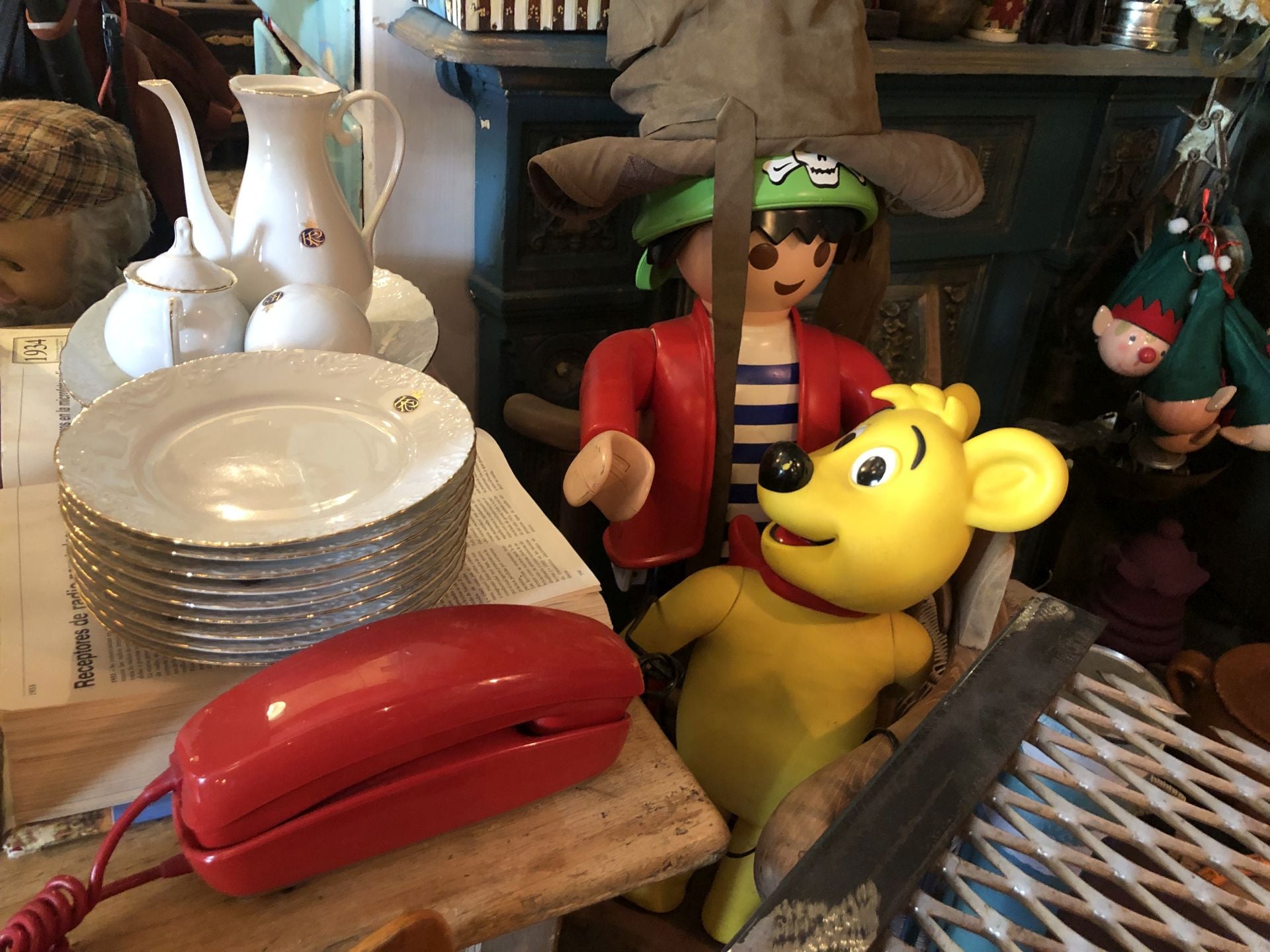 Un teléfono vintage y una vajilla de porcelana comparten espacio junto a un Playmobil y un osito de Haribo.