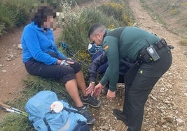Un miembro de Seguridad Ciudadana del Puesto de la Guardia Civil en Ponferrada atiende a la peregrina herida.