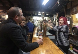 Ana Rodríguez sirve una cerveza a unos clientes en la bodega de El Pescador