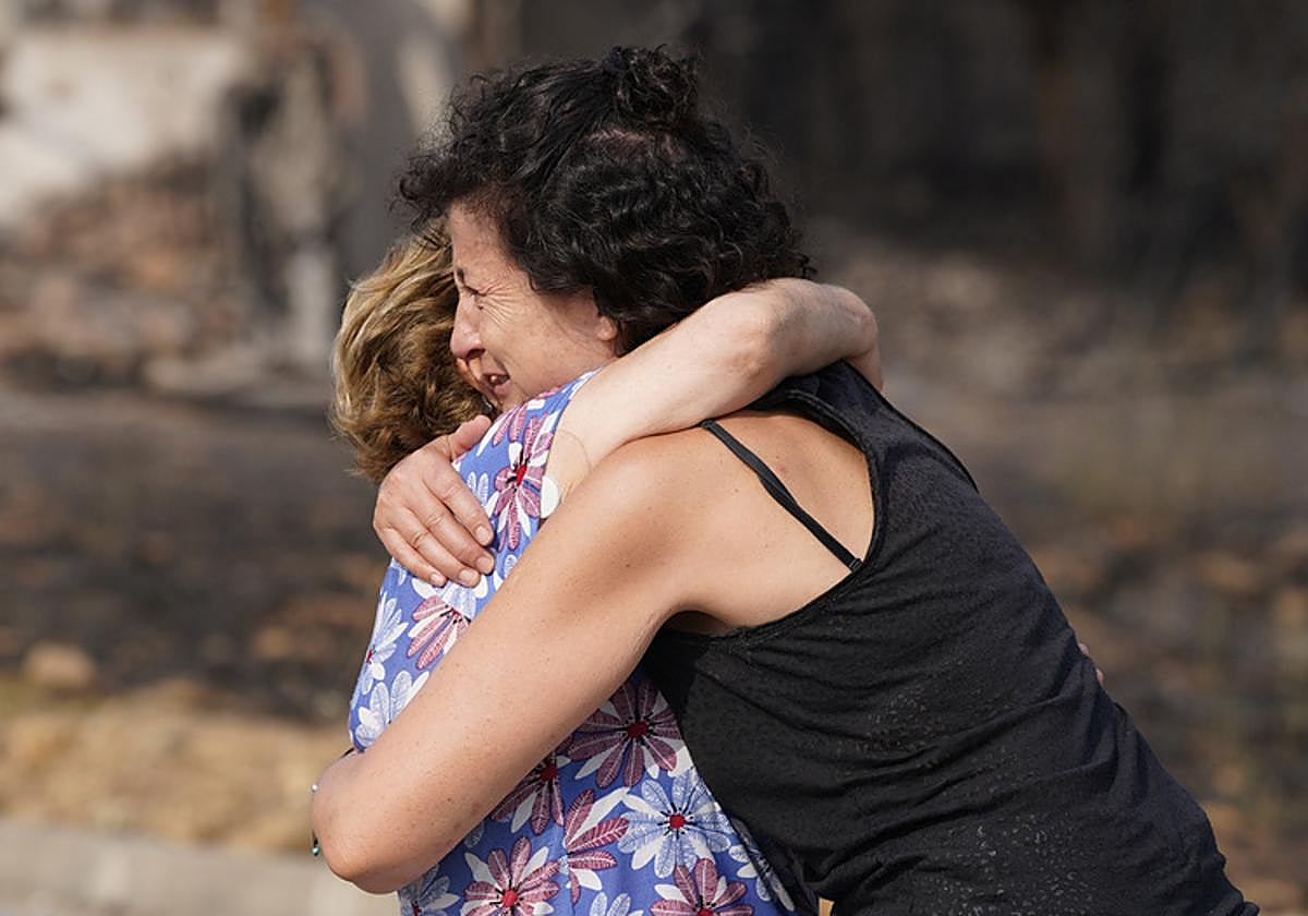 Dos vecinas de Las Médulas se abrazan y lloran ante la magnitud del desastre originado por el incendio.