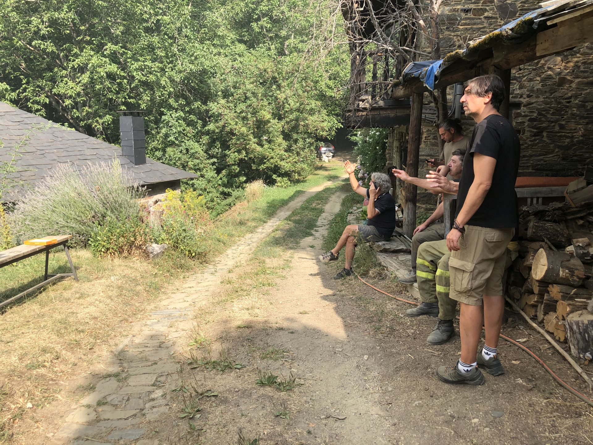 Vecinos del pueblo contemplan el intenso humo que invade el monte situado frente a la localidad.