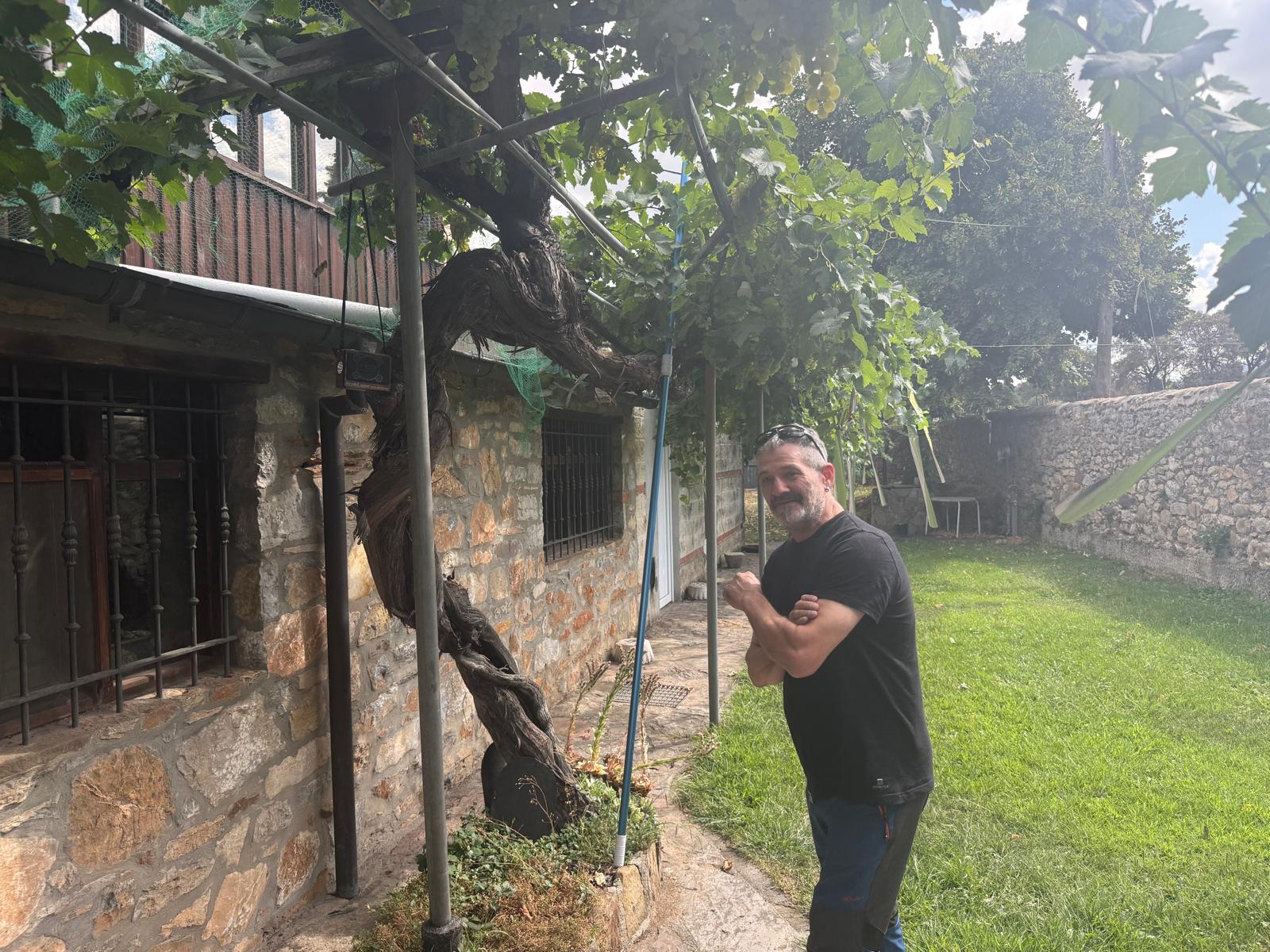 Javi Vega junto a una parra milenaria en el jardín de lo que será su nuevo restaurante.