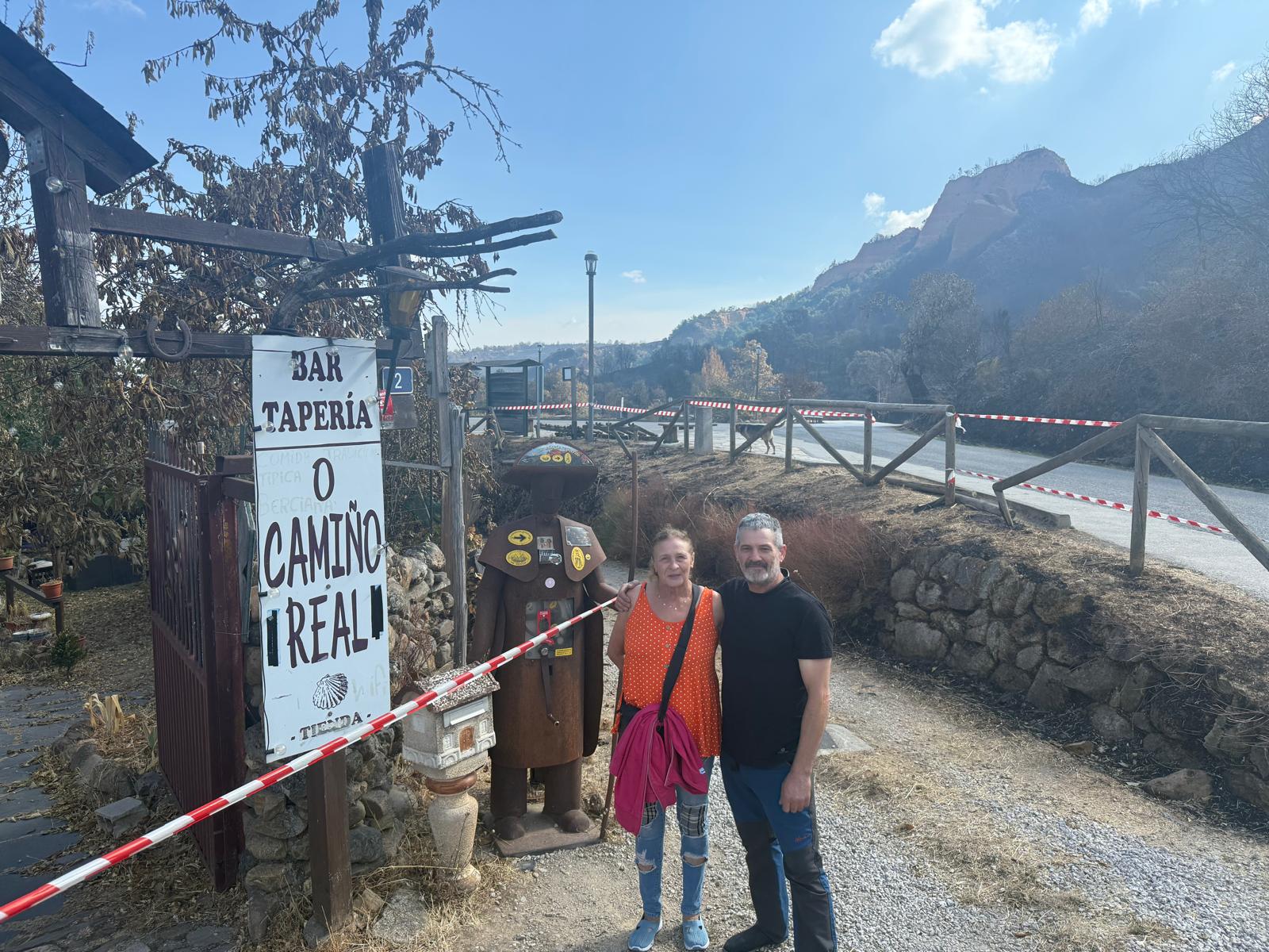 Javi y Marga junto al cartel del restaurante, intacto tras las llamas.