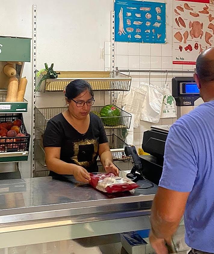 Imagen secundaria 2 - Jeny Quispe junto a su marido y sus hijos, en la tienda y atendiendo a un cliente.