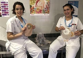 La enfermera estomaterapeuta Sandra Cereijo (D) y Antía Rodríguez (I), enfermera especialista en medicina comunitaria, muestran varias bolsas de ostomía en la consulta del Hospital del Bierzo..