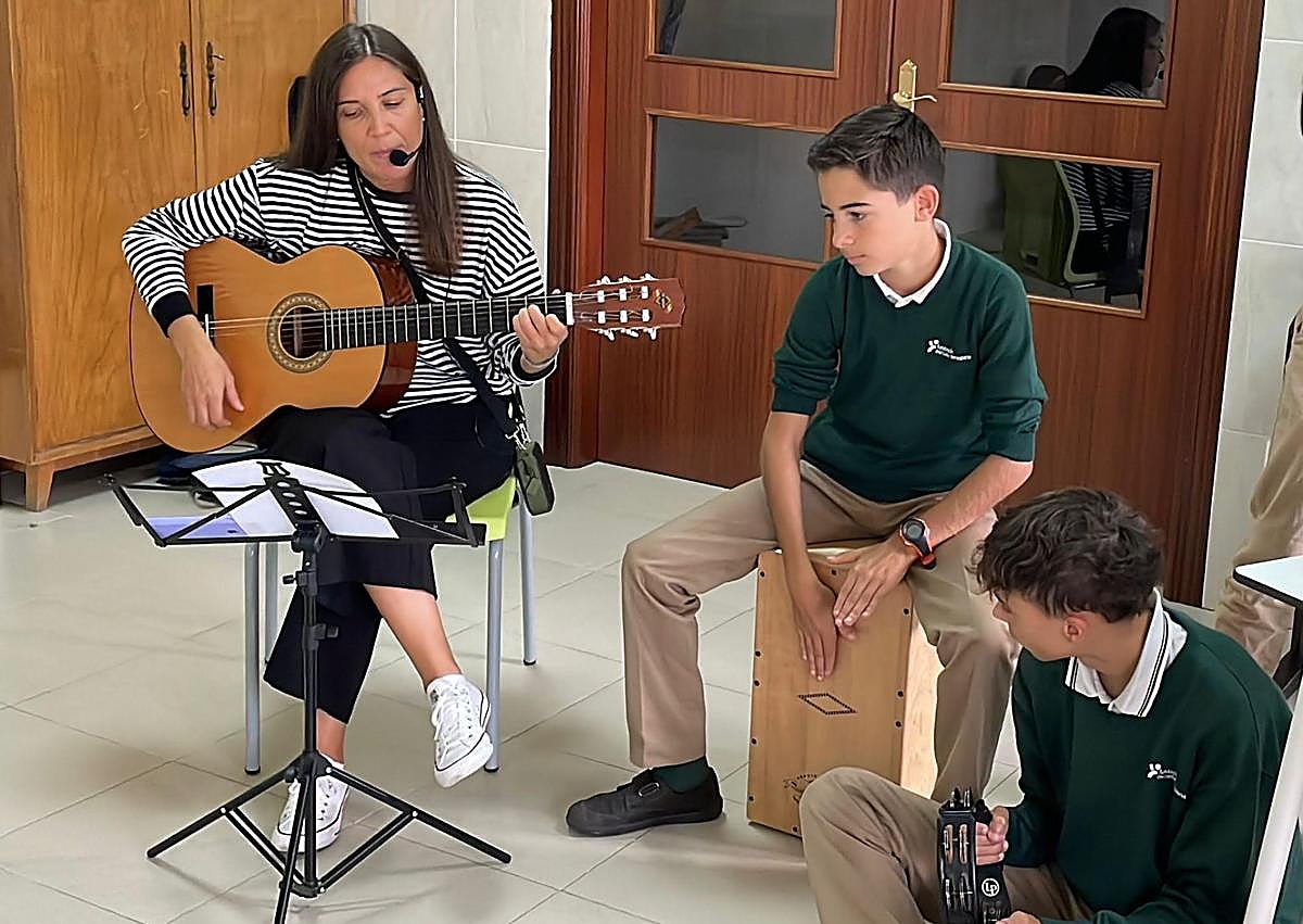 Imagen secundaria 1 - La profesora berciana en dos imágenes con sus alumnos y montrando la medalla con la inscripción '¡Viva Ponferrada!' que le regalaron.