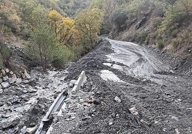 Las piedras y el barro invaden el vial de acceso a la localidad.