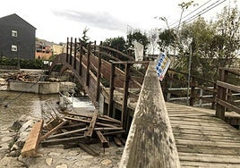 Imagen de las labores de desmontaje de la barandilla de la pasarela de madera sobre el río Burbia.