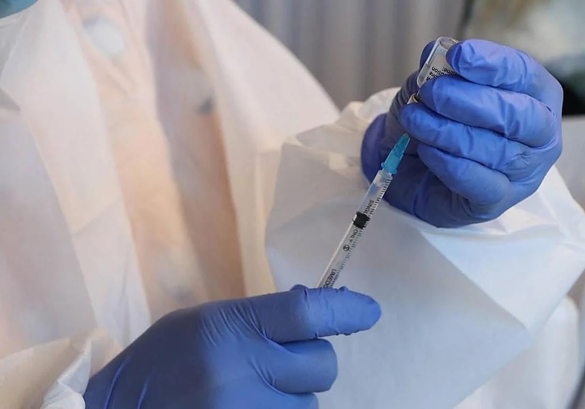 Un sanitario prepara una vacuna.