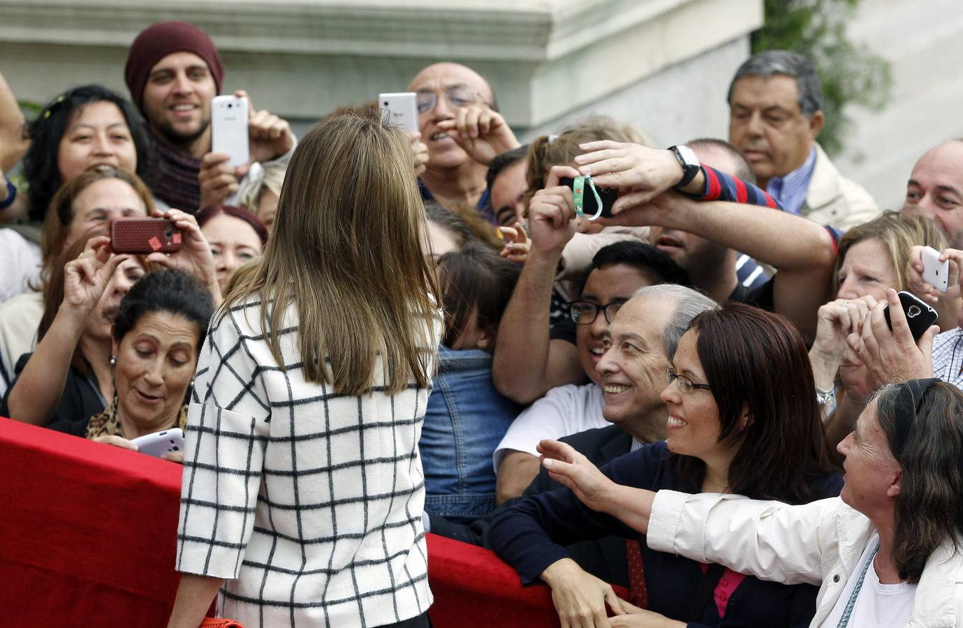 La reina Letizia saluda a los asistentes que se han acercado a las puertas del Congreso.