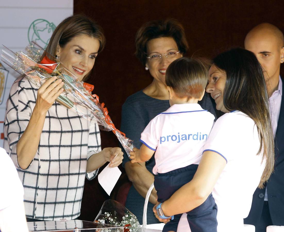 La reina Letizia recibe una rosa de un niño que junto a su familia se ha acercado a las puertas del Congreso.