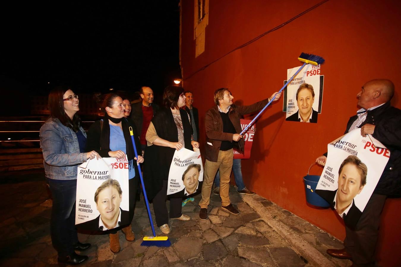 El PSOE de Llanes, pegando los primeros carteles de José Manuel Herrero.