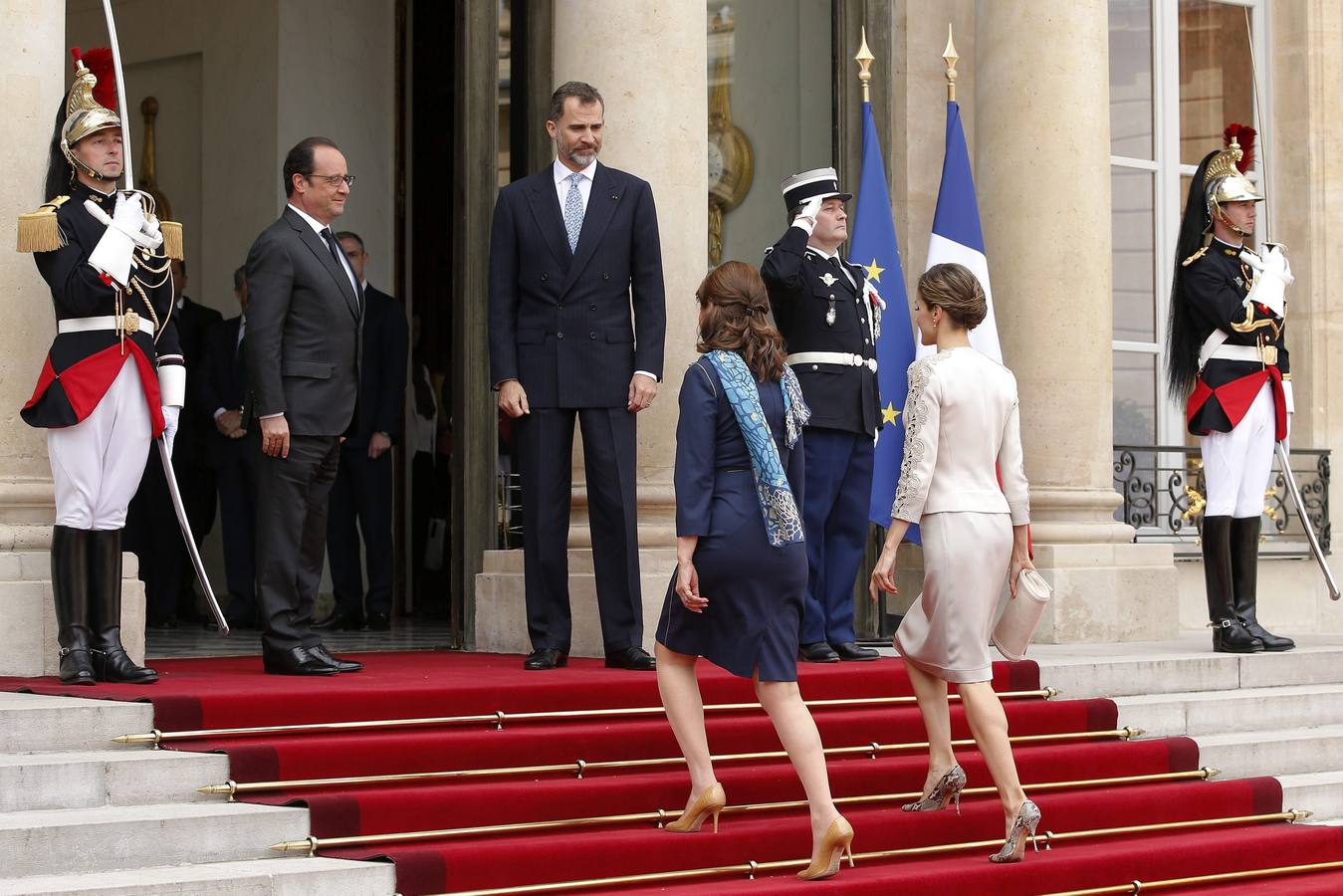 La reina Letizia y Segolene Royal suben la escalera del Palacio del Elíseo ante la atenta mirada de Felipe VI y François Holland.