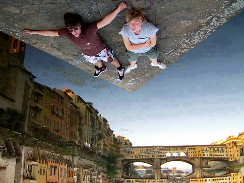 Siesta sobre el agua. El agua del río refleja los edificios y no se sabe cuál es la posición real de la fotografía.