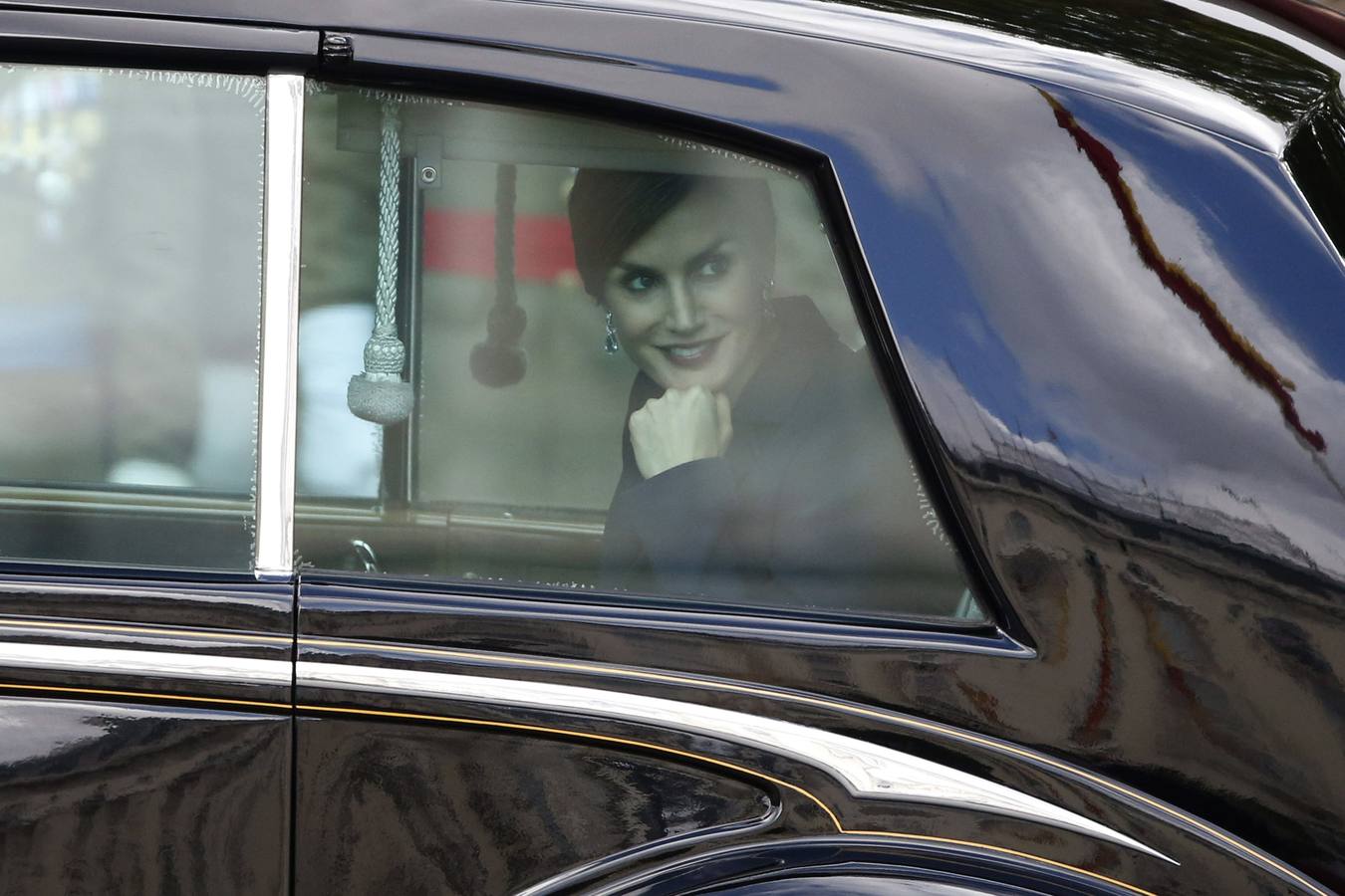 Doña Letizia sonríe tras la ventana del coche.