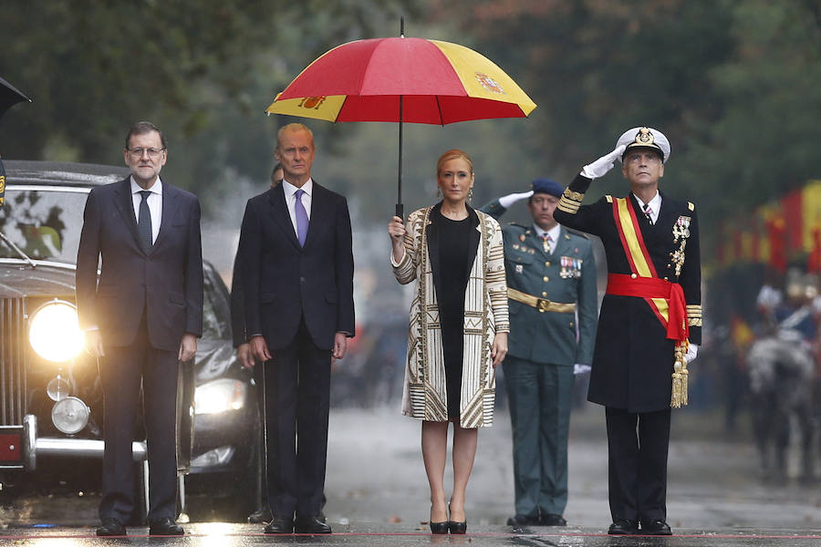 Cristina Cifuentes con su paraguas de la bandera de España junto a Pedro Morenés y Mariano Rajoy.