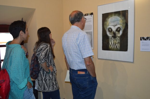 Visitantes se detienen ante una de las obras de la muestra 'El Quixote ilustráu', de Juan Hernaz. 