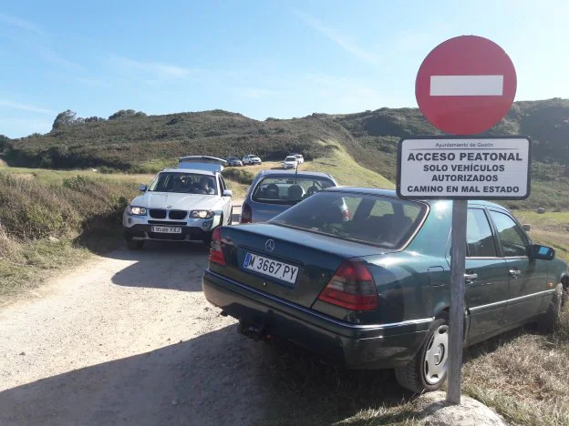 Un vehículo sale del acceso a la cala, ignorando la señal. 