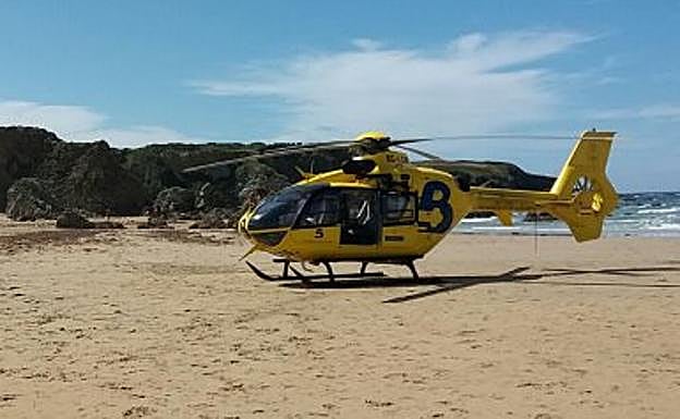 El helicóptero, en la playa de Penarronda durante la intervención. 