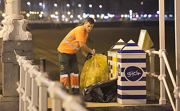 Un operario de Emulsa, en la madrugada de los Fuegos, retira la basura de las papeleras. 
