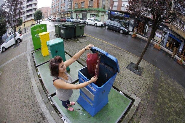 Una vecina de La Felguera utiliza los contenedores de reciclaje instalados en Langreo. 