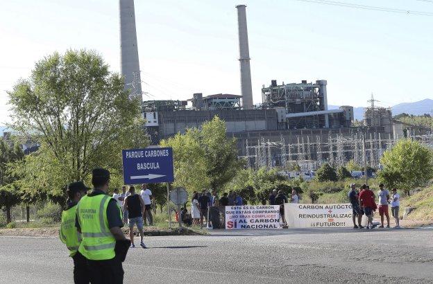 Una pareja de la Guardia Civil vigila a los trabajadores de Astur Leonesa ante Compostilla. 