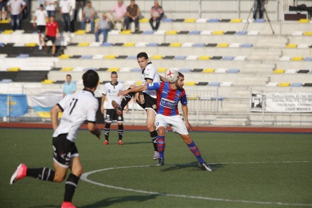 Pugna entre dos futbolistas en el centro del campo, una constante en el partido. 