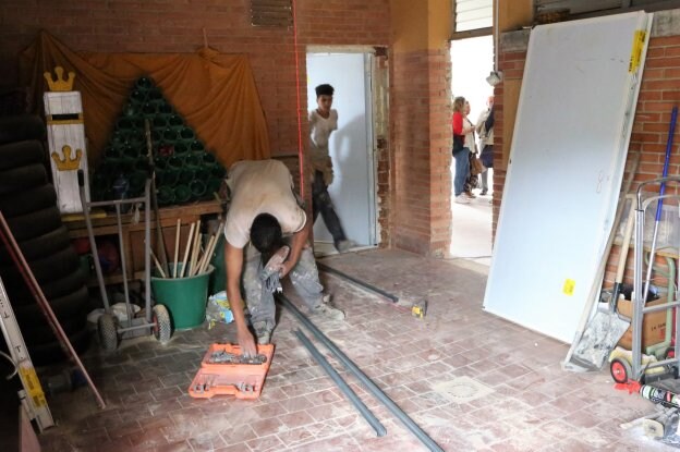 Dos obreros trabajan en el acondicionamiento del comedor en el Colegio Público Xentiquina. 