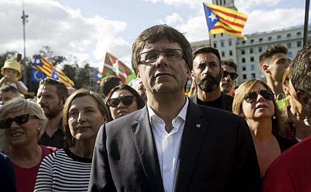 El presidente de la Generalitat de Cataluña, Carles Puigdemont (c).
