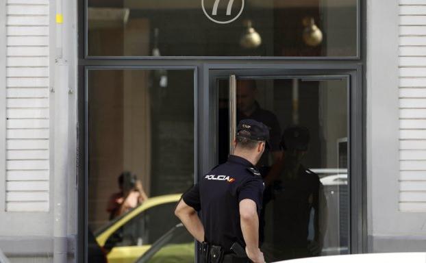 Un policía nacional junto a la puerta del edificio donde el narcotraficante sueco asesinó al subinspector Blas Gámez.
