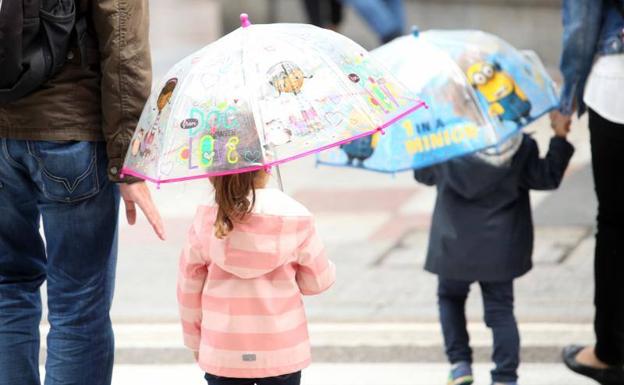 Niños con paraguas en el centro de Oviedo.