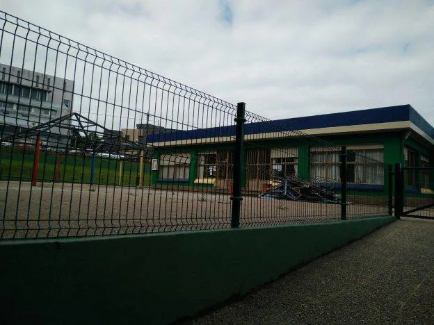 Hierros y postes de la cubierta, apilados frente al edificio de infantil. 