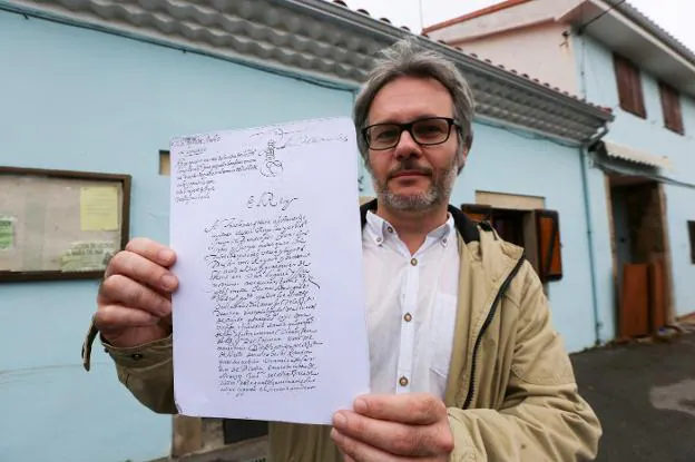 Iván Muñiz, sosteniendo una reproducción del documento de la licencia para la mina de Arnao. 